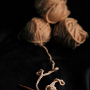 A warm, detailed shot of yarn balls and knitting needles creating a handmade piece.